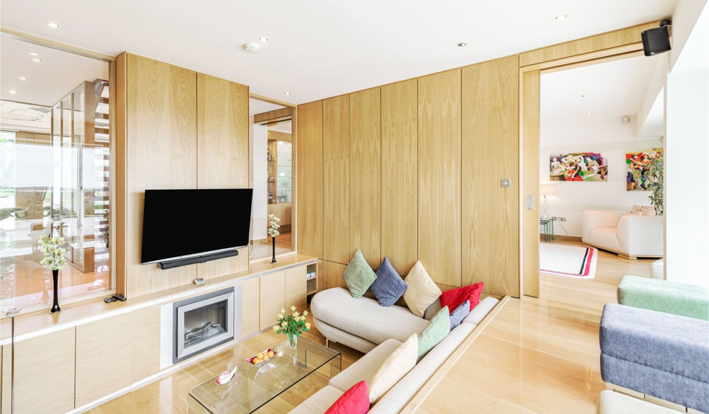 snug seating area with glass panels looking through to door and hall way